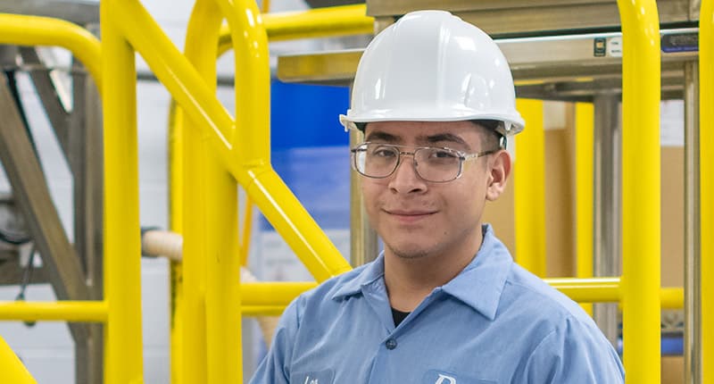 Illinois manufacturing plant worker at production line — representing the 580,000 manufacturing employees across Chicago, Schaumburg, Elk Grove Village, and the broader Illinois industrial economy