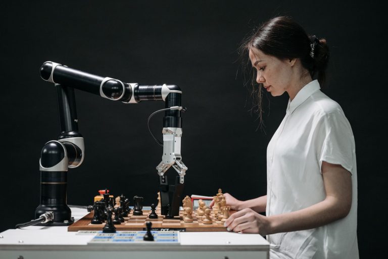 Woman playing chess against a robotic arm