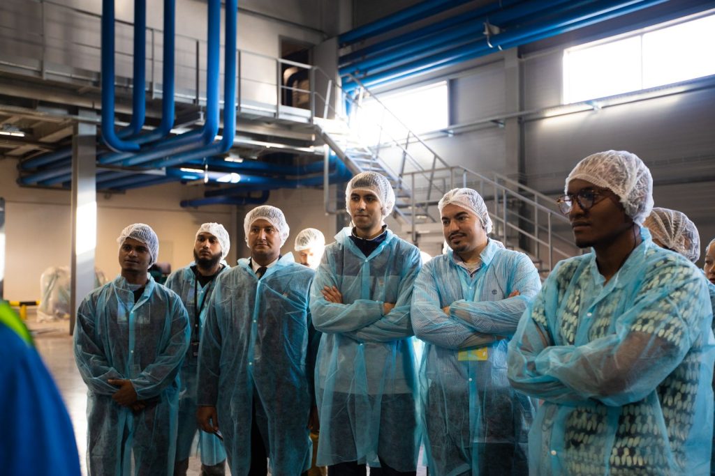 Group in protective coats and hairnets on a plant tour