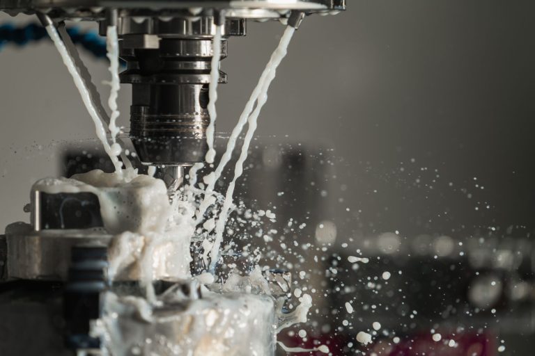 CNC machine cutting metal with coolant spraying