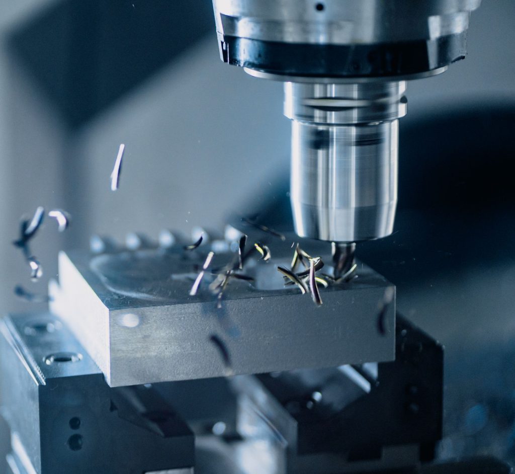 CNC milling machine cutting a metal block