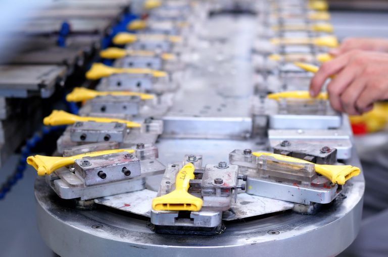 Assembly fixture with clamps on a contract manufacturing line