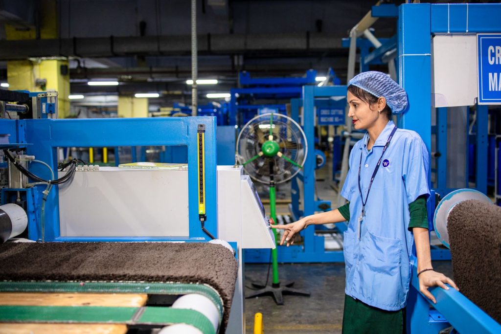 Operator in a hairnet running production equipment