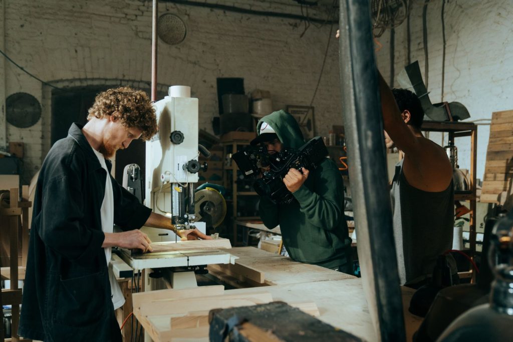 Video crew filming a craftsman at work in a workshop