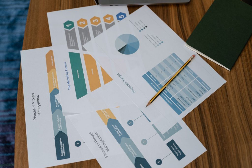 Printed marketing charts and reports spread on a desk
