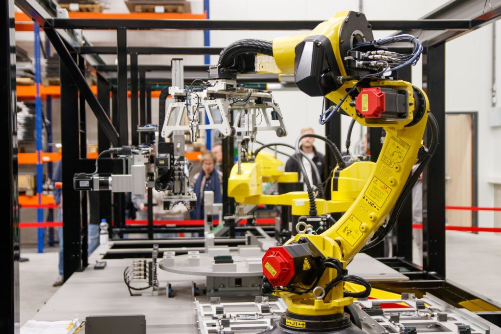 Yellow industrial robot arm in an automated work cell