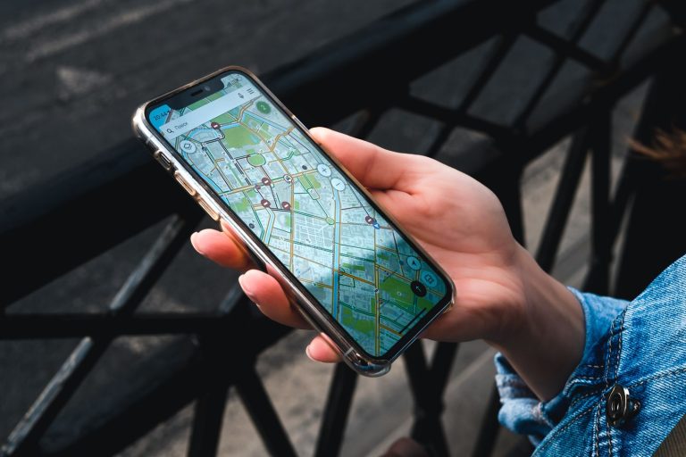 Hand holding a smartphone displaying a map