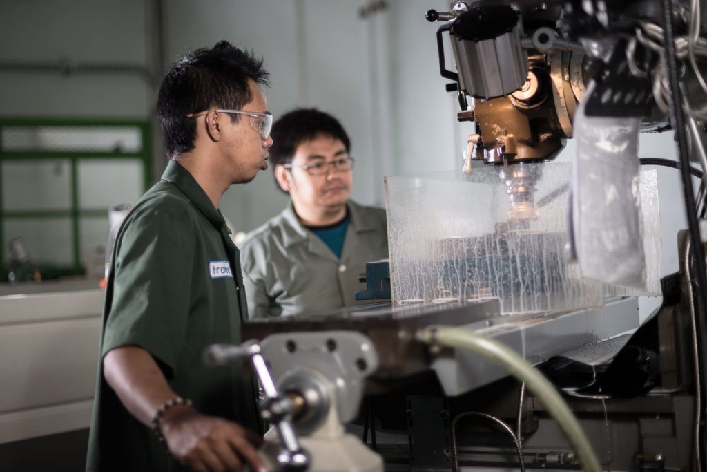 Two machinists working together at a CNC machine