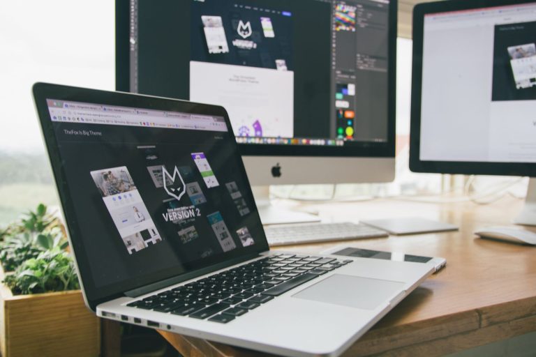 Website design mockups on a laptop and desktop monitor