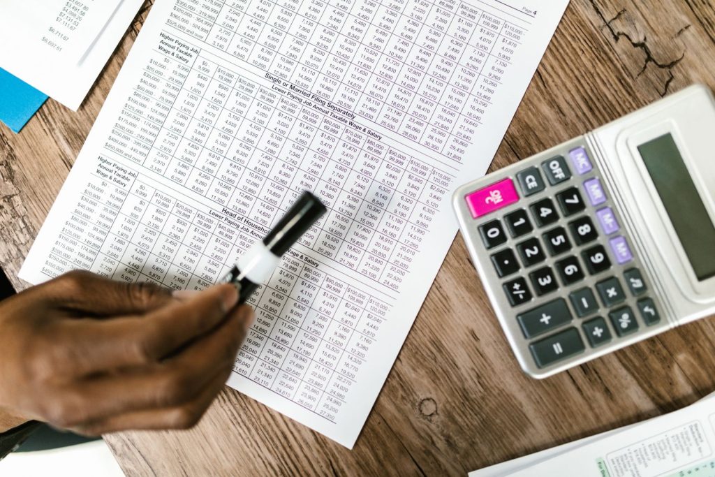 Printed budget spreadsheet with a calculator and pen