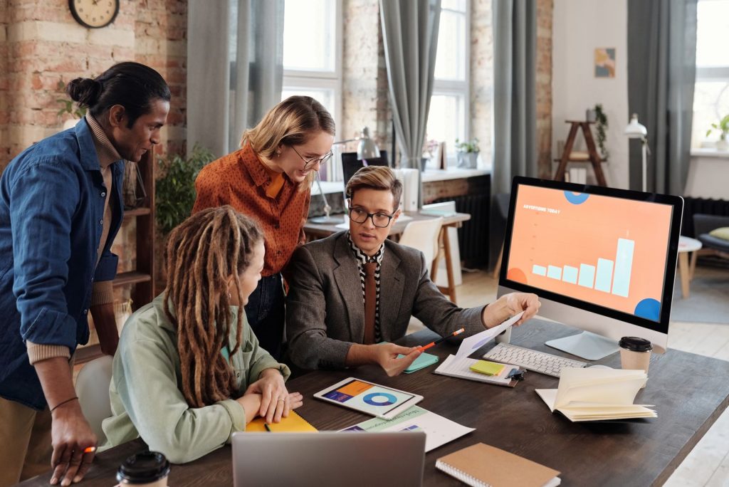 Marketing team reviewing analytics on a desktop monitor