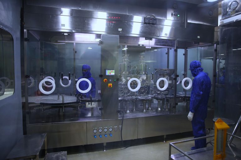 Cleanroom production line with isolator equipment and a technician in protective gear