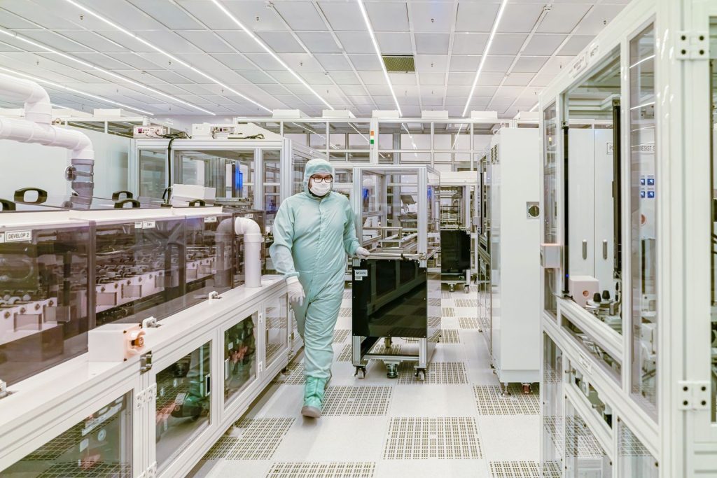 Technician in a cleanroom suit walking through a sterile manufacturing area
