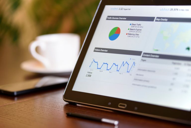 Tablet showing advertising analytics charts on an office desk