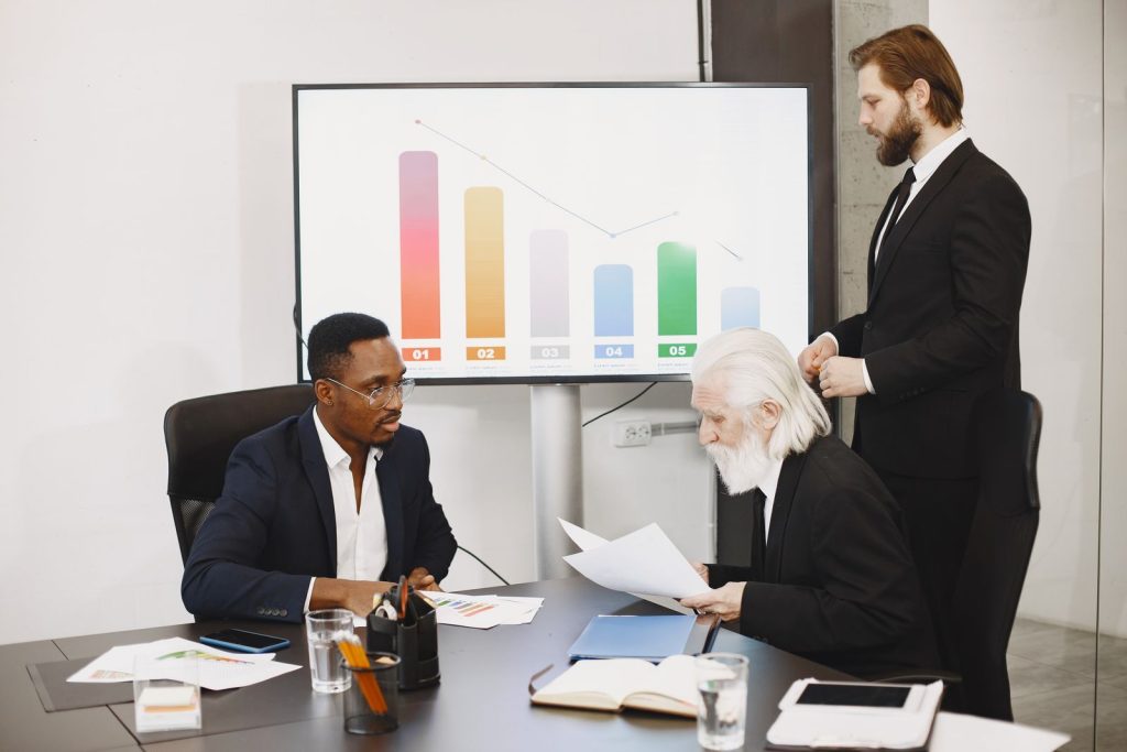 Manager presenting bar charts to executives in a boardroom