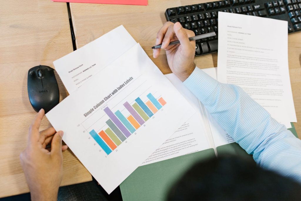 Professional reviewing a printed performance report with bar charts