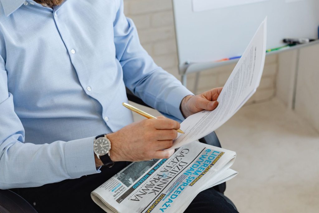 Professional reviewing a printed document with a pen in hand