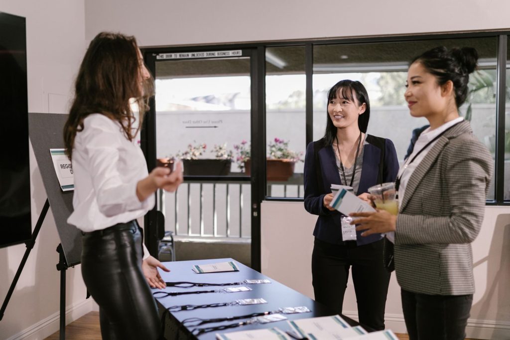 Exhibitors talking with a visitor at a trade show booth